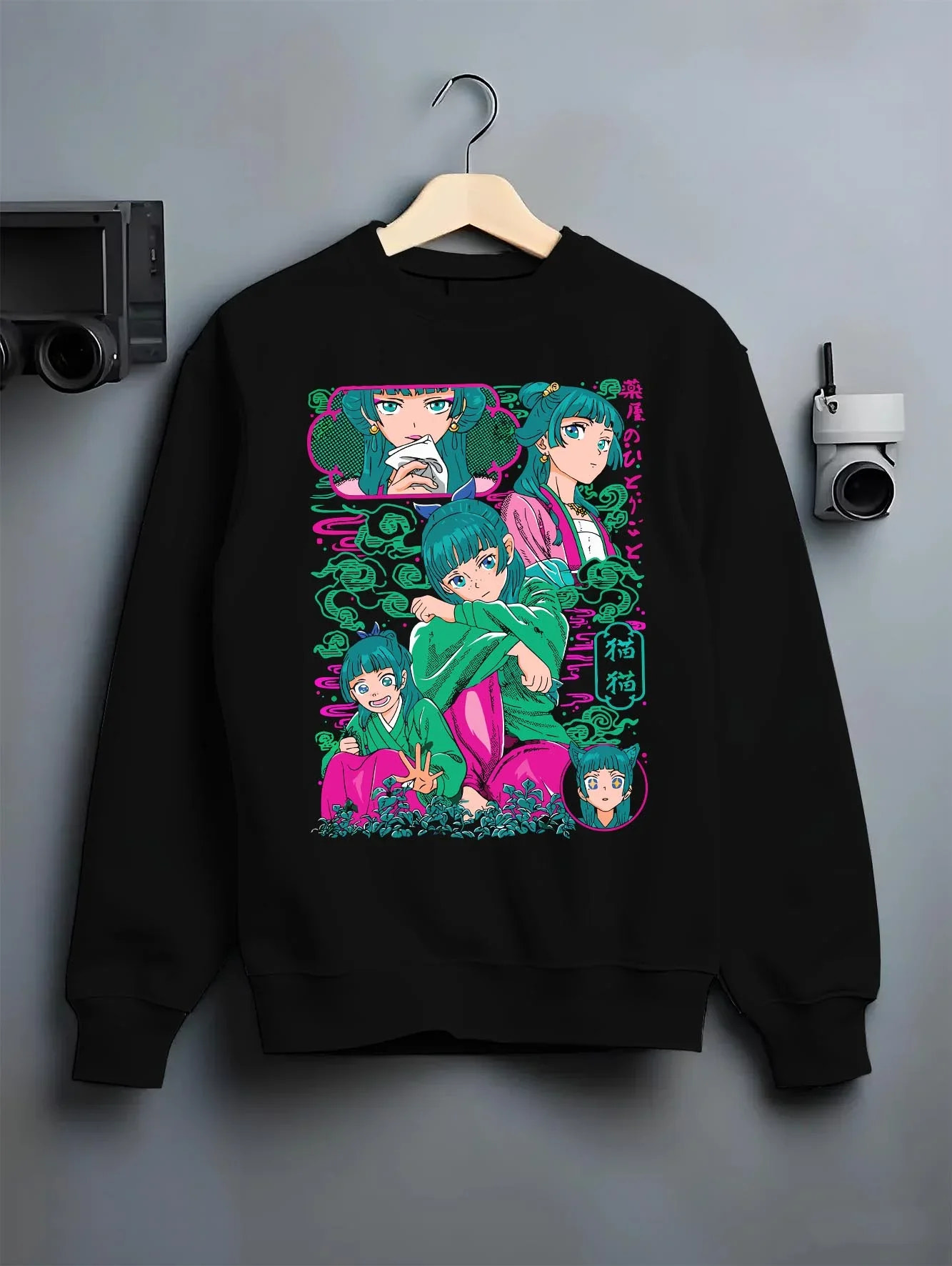 Black crewneck sweatshirt on hanger with Apothecary Diaries Hoodie Maomao Pink Hair Trio Panel graphic bold anime graphic.