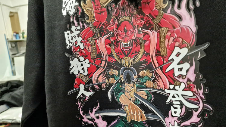 Black One Piece Zoro hoodie featuring Roronoa Zoro three-sword style attack with fiery red Asura demon design, premium Kunai anime clothing for collectors.