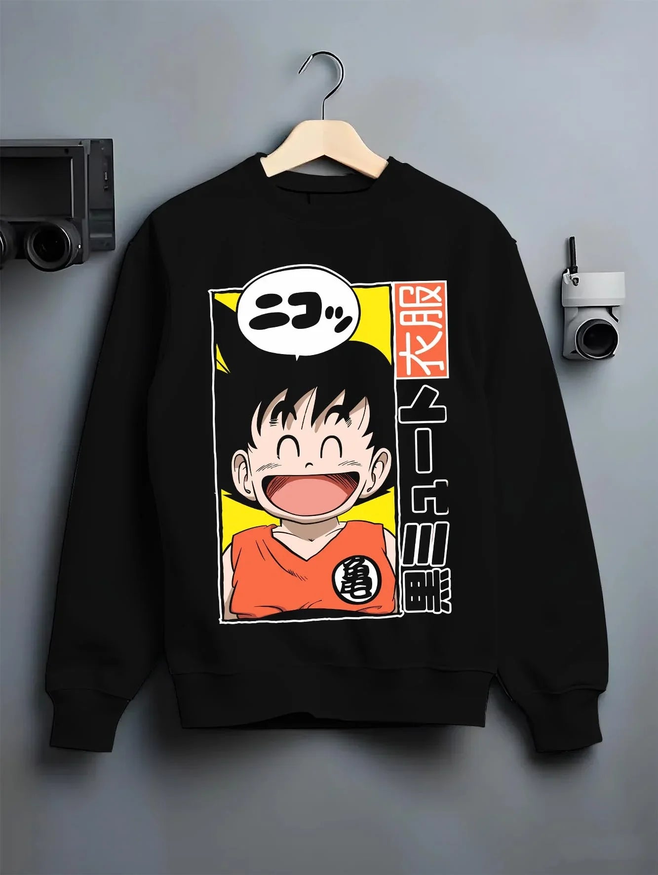 Black crewneck sweatshirt on hanger with Krillin Hoodie Dragon Ball Retro Nimbus Flying Pose graphic streetwear graphic.