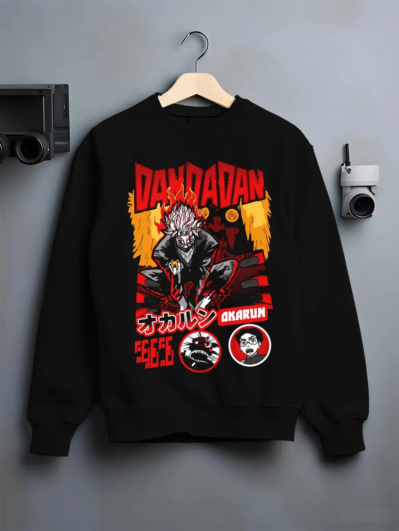 Black crewneck sweatshirt on hanger with Okarun Hoodie Dandadan Possessed Spirit Alien Fight graphic premium wear.