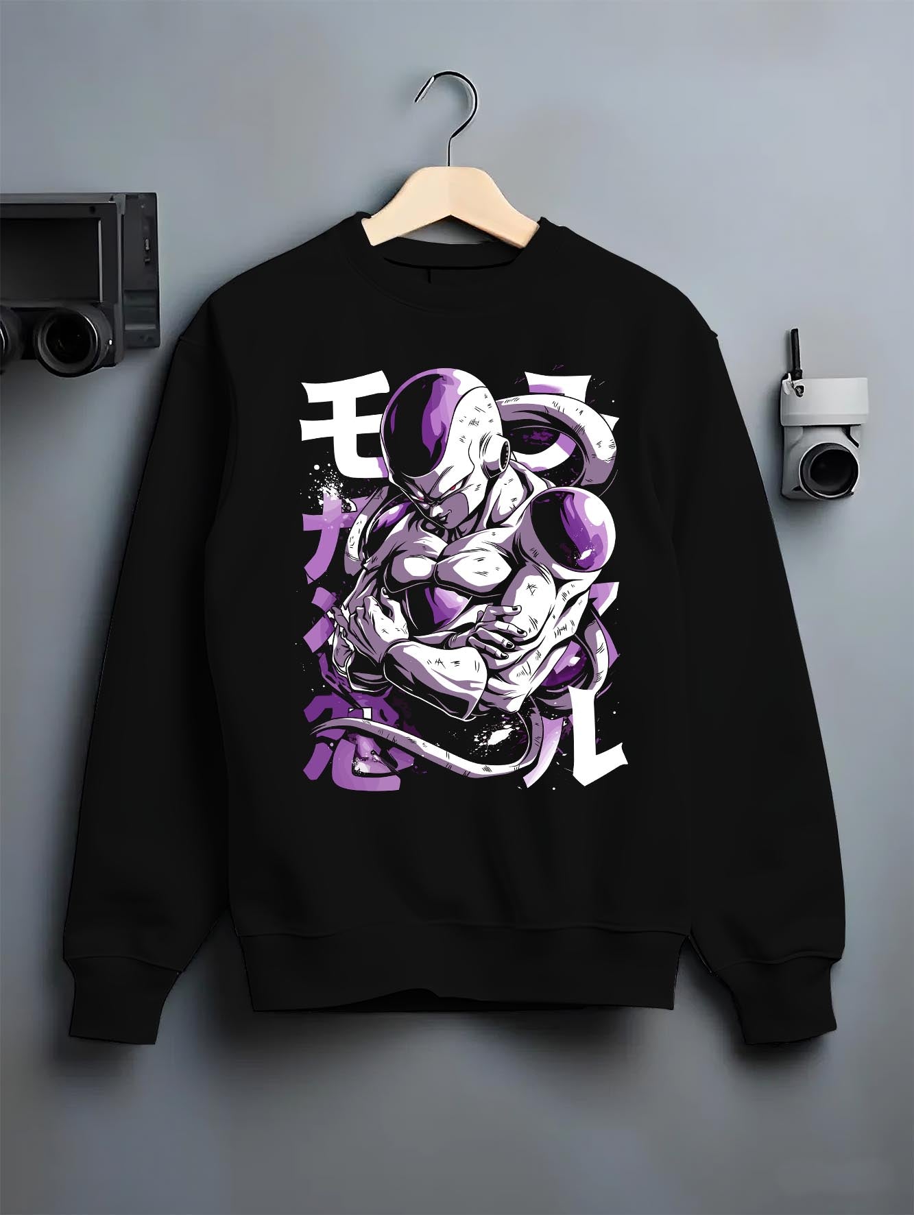 Black crewneck sweatshirt on a hanger against a grey wall, featuring Frieza Dragon Ball Z retro manga graphic with folded arms and bold purple villain aura artwork.